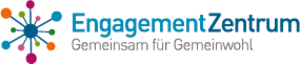 Das Bild zeigt das Logo des "EngagementZentrum". Links ist eine stilisierte, bunte Grafik mit mehreren verbundenen Punkten in verschiedenen Farben, die wie ein Netzwerk aussehen. Rechts daneben steht der Schriftzug "EngagementZentrum" in Blau und darunter der Slogan "Gemeinsam für Gemeinwohl" in Schwarz.