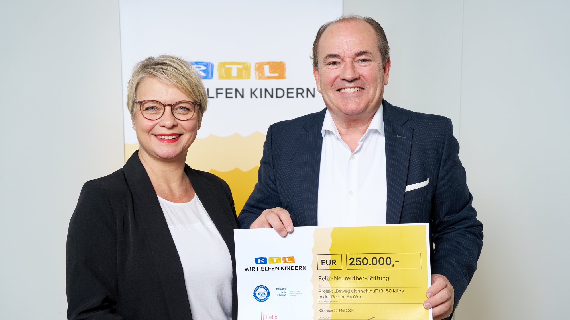 Monika Schmidt erhielt als Treuhänderin der Felix-Neureuther-Stiftung und Geschäftsführerin des gemeinwohlorientierten EngagementZentrums Braunschweig den symbolischen Spendenscheck über 250.000 Euro. Zwei Personen stehen lächelnd nebeneinander. Die rechte Person hält einen Spendencheck in der Hand.